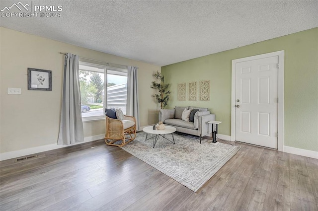 living room featuring light hardwood / wood-style floors and a textured ceiling