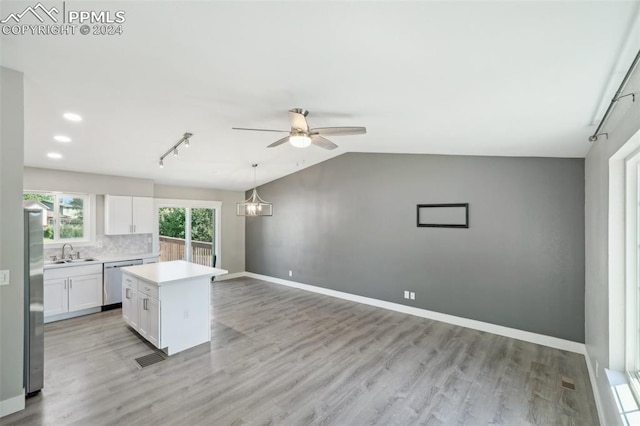 kitchen featuring light hardwood / wood-style flooring, appliances with stainless steel finishes, a center island, sink, and white cabinets