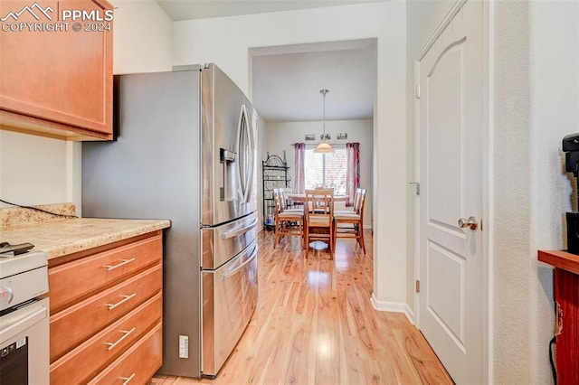 kitchen featuring stainless steel refrigerator with ice dispenser, pendant lighting, and light wood-type flooring