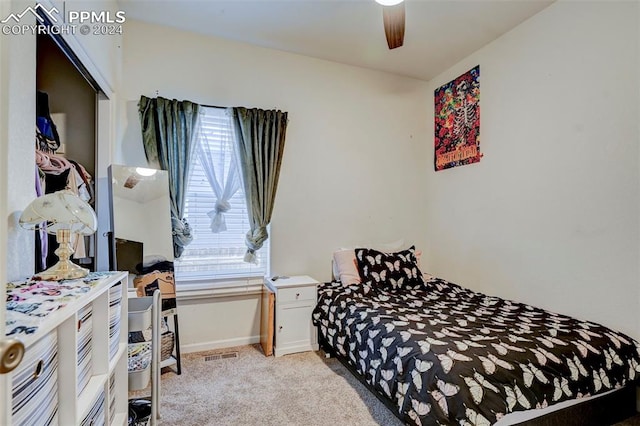 carpeted bedroom featuring multiple windows and ceiling fan