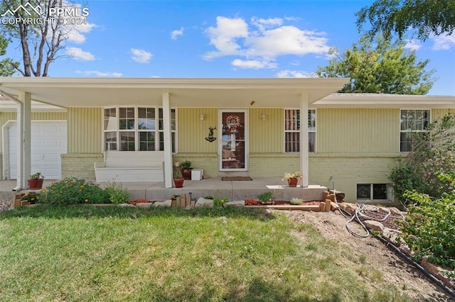 view of front facade featuring a garage, a front lawn, and covered porch