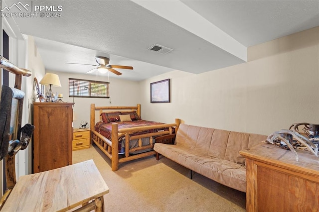 bedroom featuring ceiling fan, light carpet, and a textured ceiling