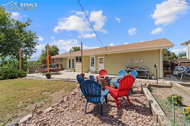 rear view of house with a deck, a patio, and an outdoor fire pit