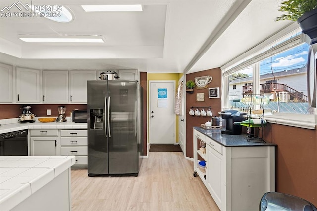 kitchen with dishwasher, stainless steel fridge, tile counters, and white cabinets