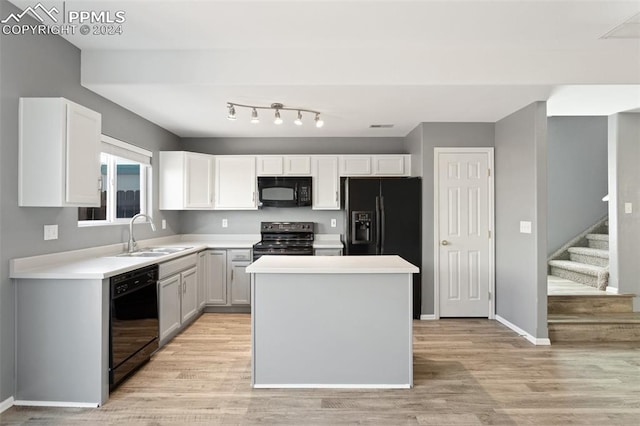 kitchen with black appliances, light hardwood / wood-style floors, white cabinetry, and sink