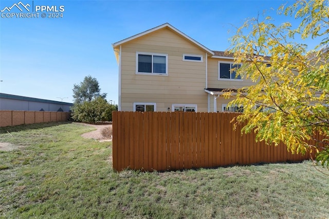 rear view of property featuring a lawn