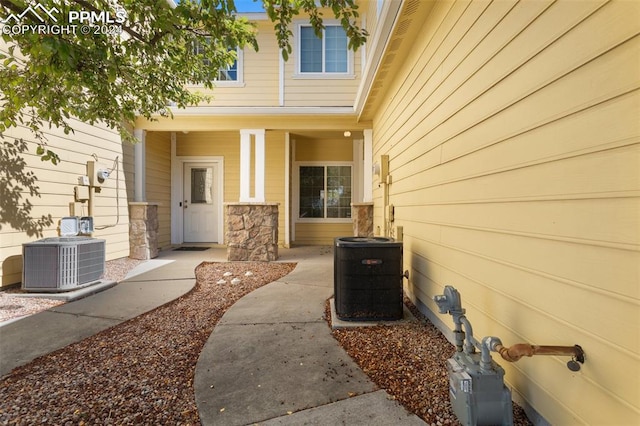 doorway to property featuring central AC and a porch