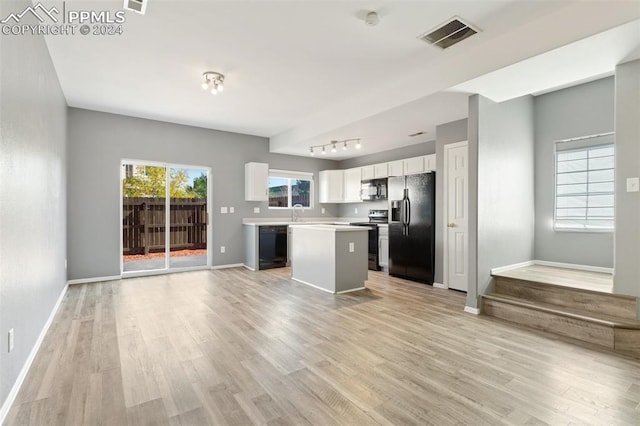 kitchen featuring light wood-type flooring, a center island, white cabinetry, rail lighting, and black appliances