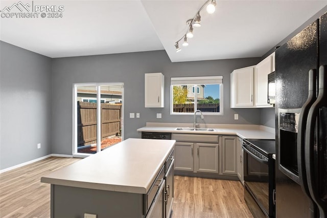 kitchen featuring gray cabinetry, light wood-type flooring, black appliances, and sink