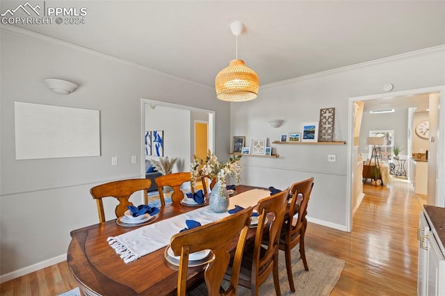 dining area featuring ornamental molding and light hardwood / wood-style flooring