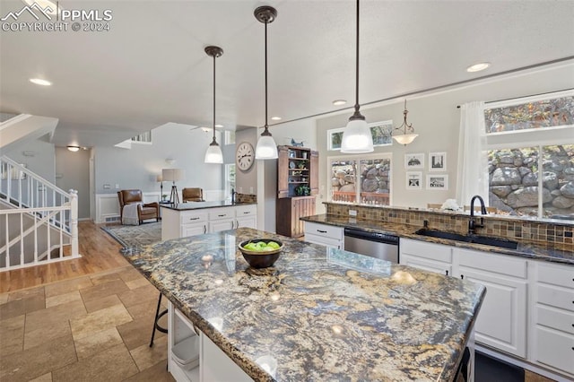 kitchen featuring wall chimney exhaust hood, stainless steel appliances, white cabinets, and decorative backsplash