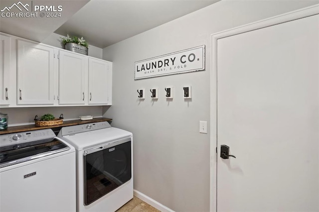 laundry room with separate washer and dryer and cabinets