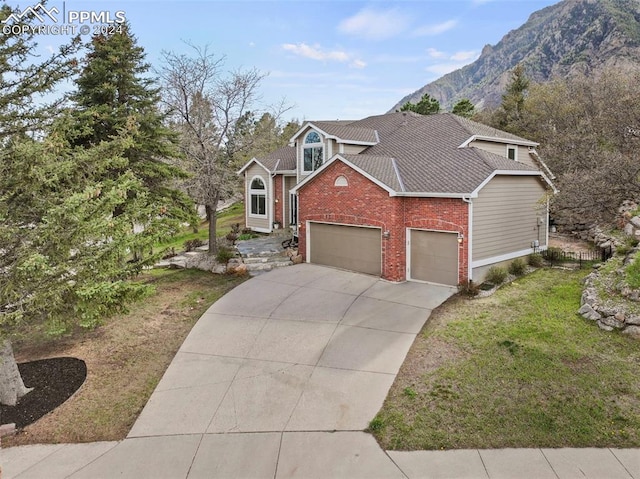 view of front facade with a mountain view, a garage, and a front lawn