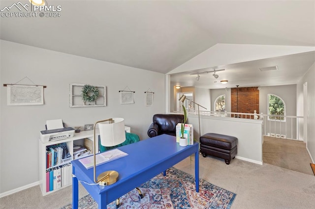 office featuring lofted ceiling, rail lighting, and light carpet