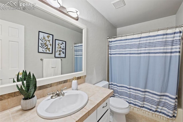 bathroom featuring curtained shower, tile patterned flooring, toilet, and vanity