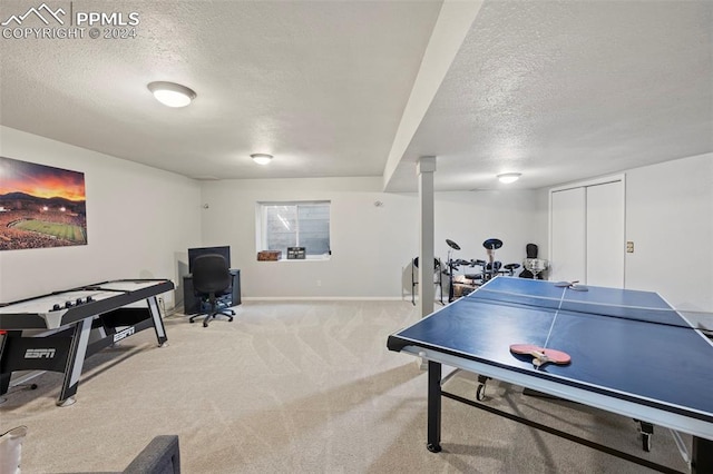 playroom featuring decorative columns, a textured ceiling, and light colored carpet