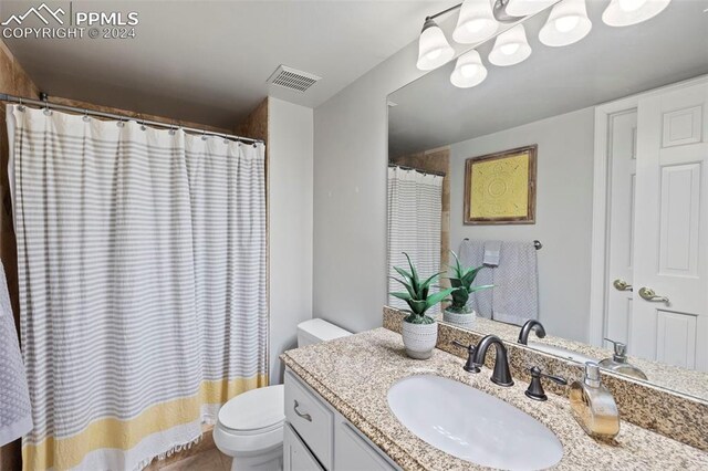 bathroom with a shower with shower curtain, toilet, and vanity