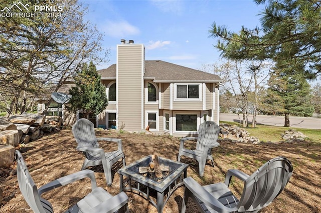 rear view of house featuring an outdoor fire pit