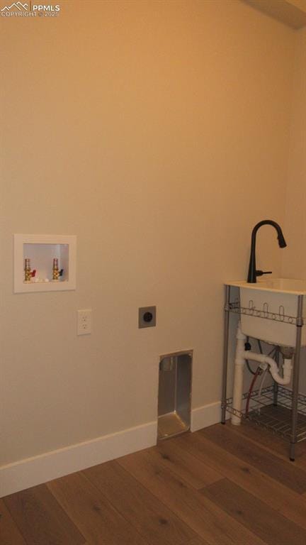 clothes washing area with hookup for a washing machine, electric dryer hookup, and hardwood / wood-style flooring