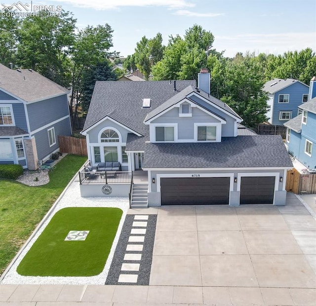 view of front facade featuring a porch, a front yard, and a garage