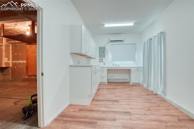 interior space with light hardwood / wood-style floors, a baseboard heating unit, electric panel, and a wall mounted AC