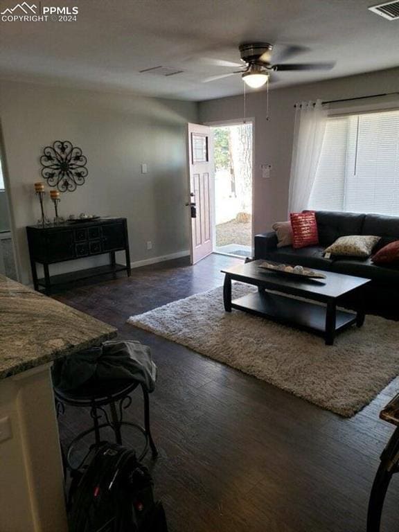 living room with dark hardwood / wood-style floors and ceiling fan