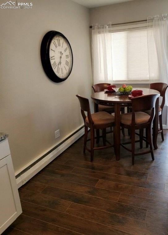 dining area featuring dark hardwood / wood-style flooring and a baseboard heating unit