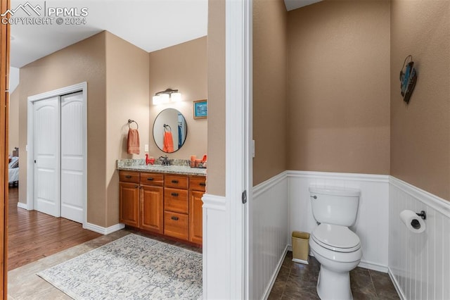 bathroom with vanity, toilet, and hardwood / wood-style flooring