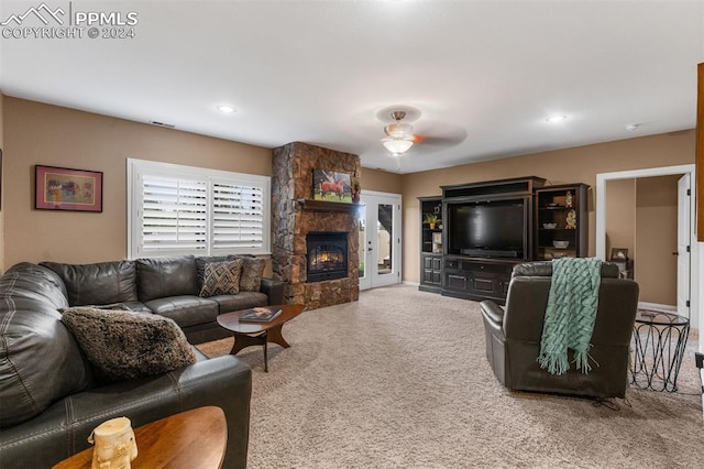 carpeted living room featuring ceiling fan and a fireplace