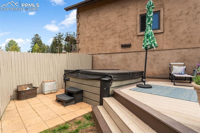 view of patio / terrace featuring a wooden deck and a hot tub