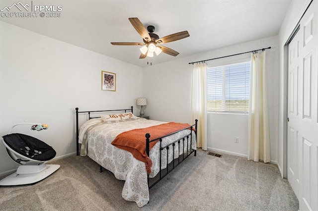 carpeted bedroom featuring ceiling fan and a closet