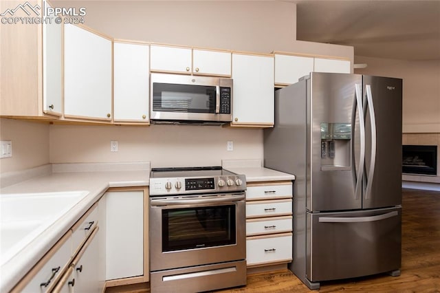 kitchen featuring wood-type flooring, white cabinetry, and stainless steel appliances