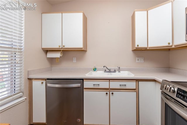 kitchen with appliances with stainless steel finishes, sink, and white cabinets