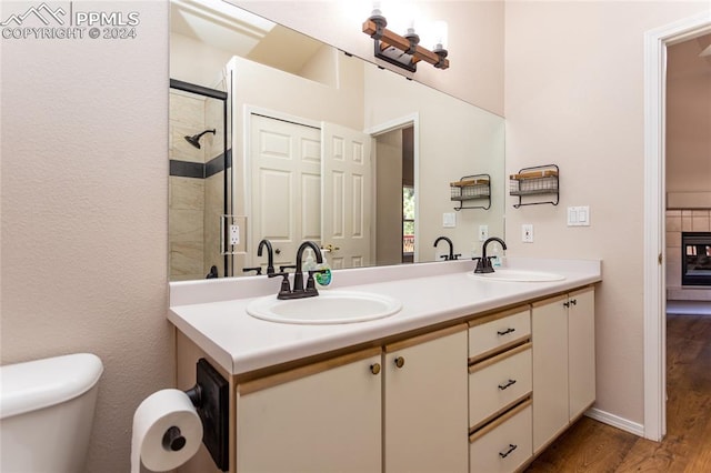 bathroom with walk in shower, wood-type flooring, vanity, and toilet