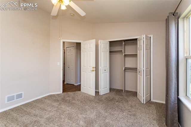 unfurnished bedroom featuring lofted ceiling, carpet, multiple windows, and ceiling fan