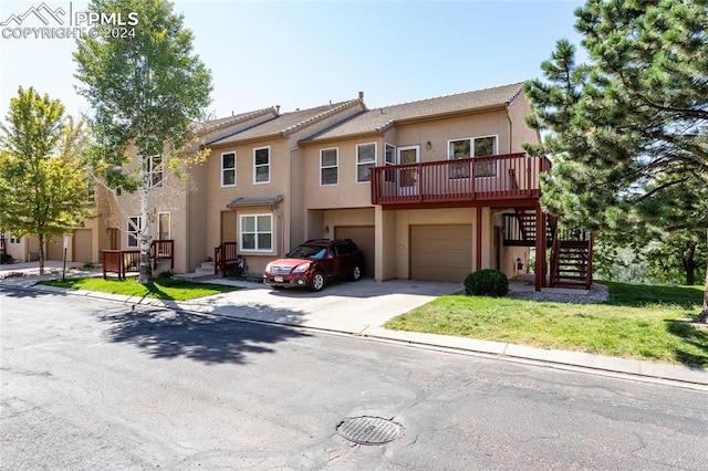 multi unit property featuring a garage and a wooden deck