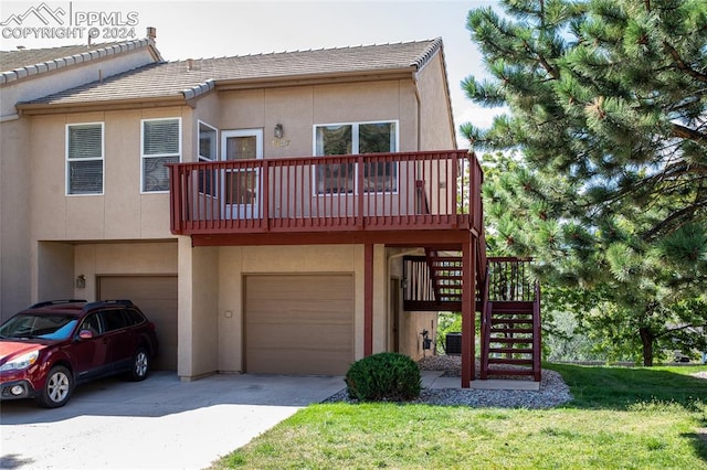 multi unit property with central AC unit, a garage, and a front lawn