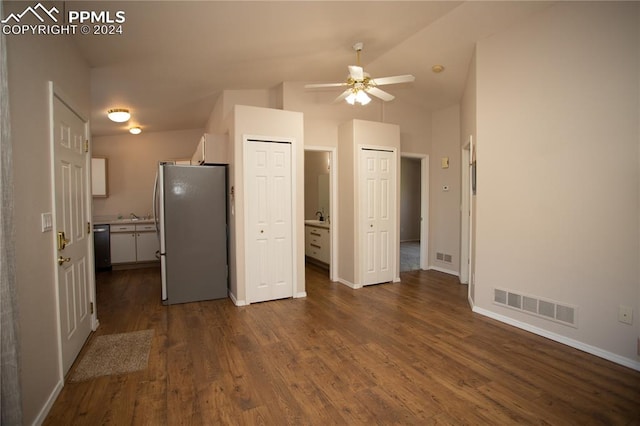 interior space featuring dark hardwood / wood-style floors, lofted ceiling, connected bathroom, ceiling fan, and stainless steel fridge