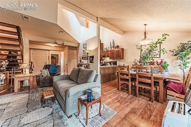 living room featuring vaulted ceiling and a textured ceiling