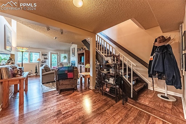 stairs with a textured ceiling and wood-type flooring