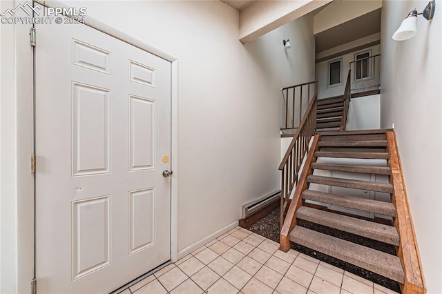 staircase featuring baseboard heating and tile patterned floors