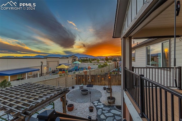 balcony at dusk with an outdoor fire pit and a patio area