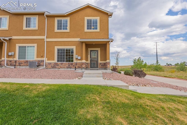 view of front of house featuring a front lawn and central AC