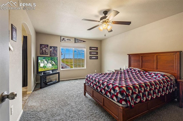 bedroom with a textured ceiling, carpet flooring, and ceiling fan