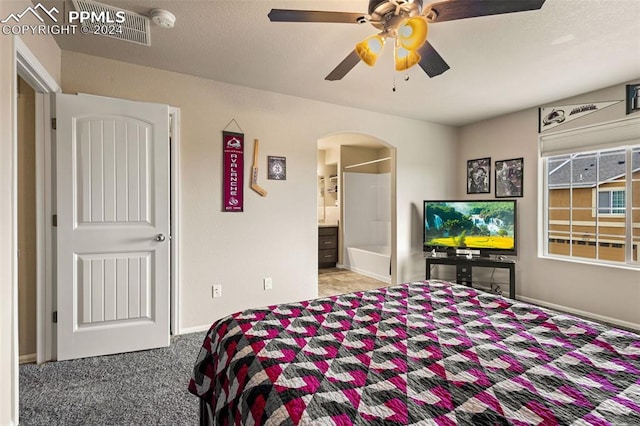 bedroom with light colored carpet, ceiling fan, and ensuite bathroom