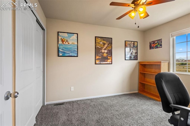 carpeted home office featuring ceiling fan