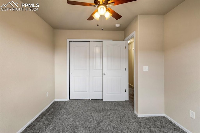 unfurnished bedroom with dark carpet, ceiling fan, and a closet