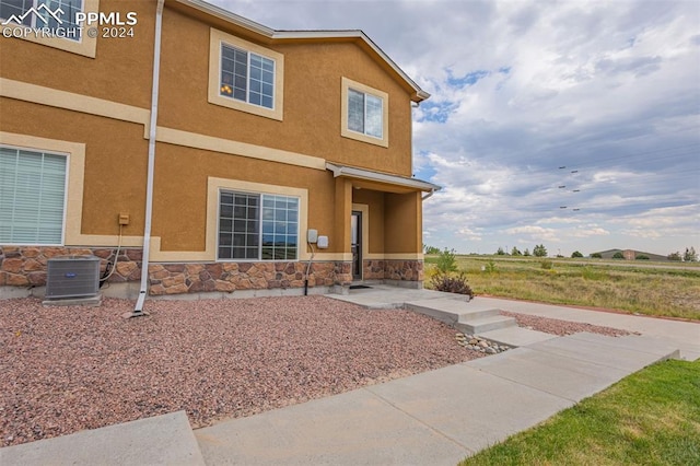 view of front of property featuring a patio and central AC