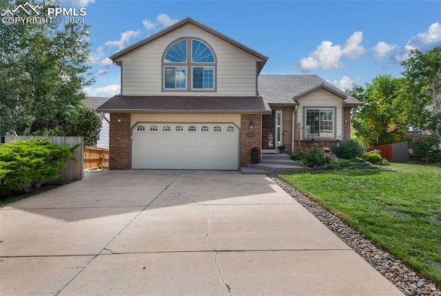 view of property featuring a garage and a front yard