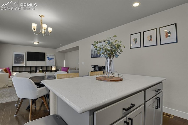 kitchen with a chandelier, a center island, dark wood-type flooring, and decorative light fixtures